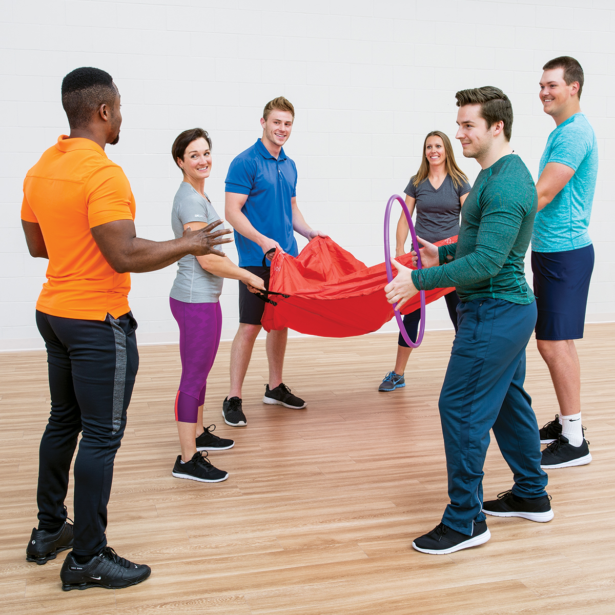 SPARK representative smiles with a football in hand, ready to lead an on-site training program.